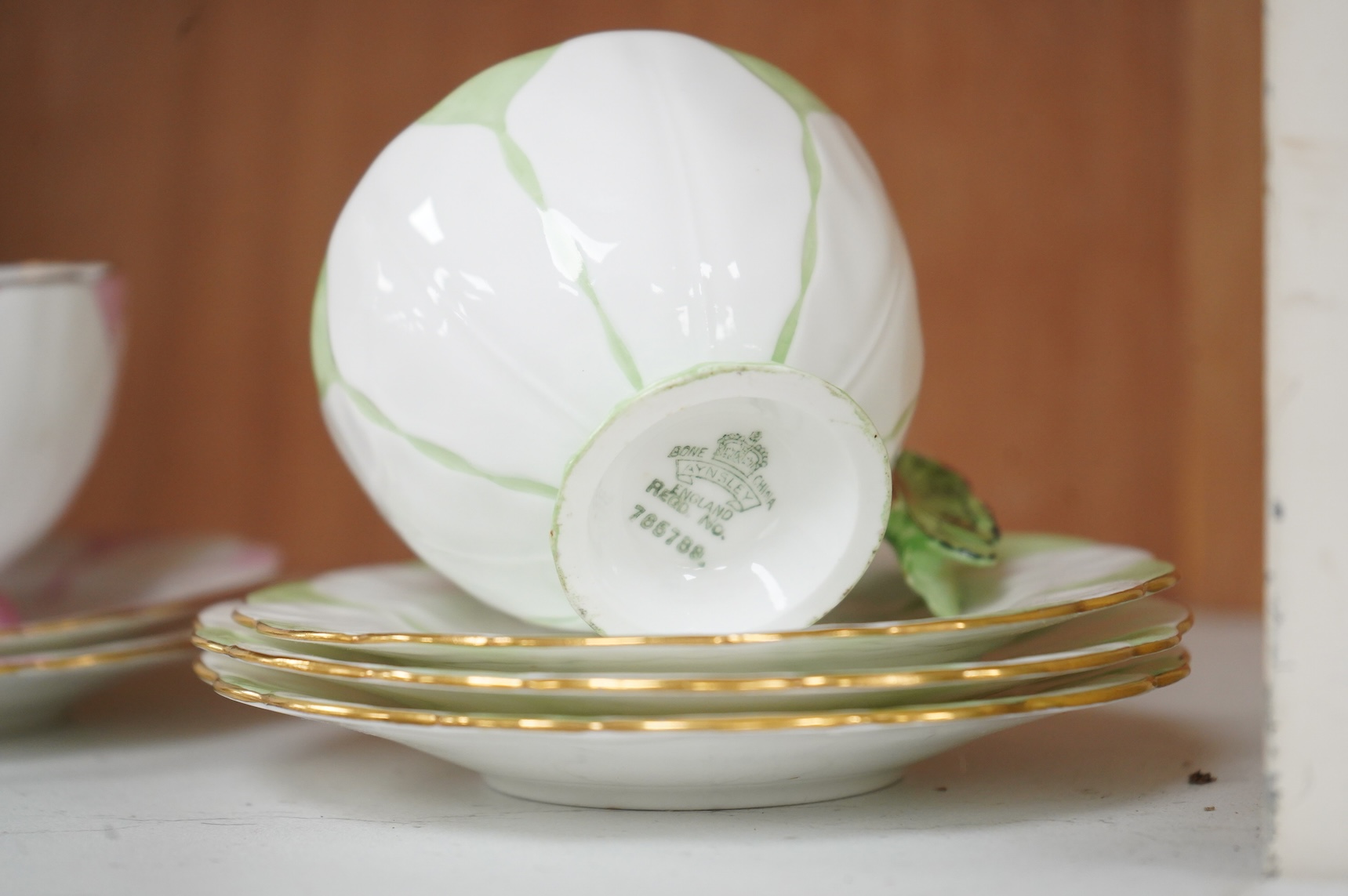 Two Aynsley trios with butterfly handles and one extra saucer, numbered 785788